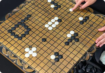 Een klassiek Go-bord met geplaatste zwarte en witte stenen tijdens een tactisch spel.